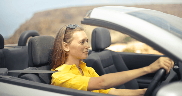 Woman driving convertible car