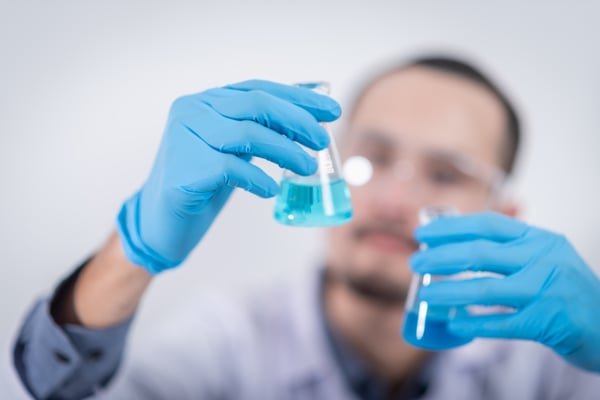 Scientist with Erlenmeyer flasks