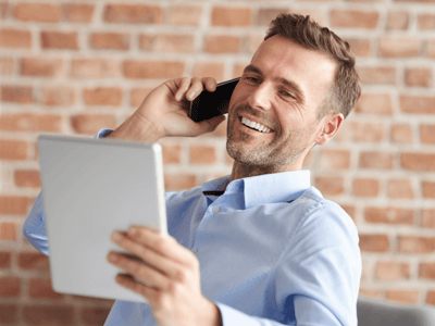 Professional on phone, looking at tablet
