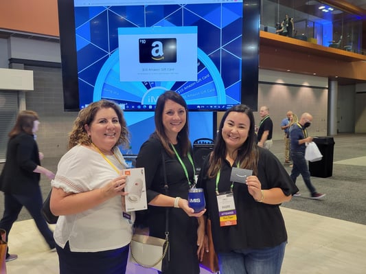 ASAE attendees holding up prizes from the prize wheel.